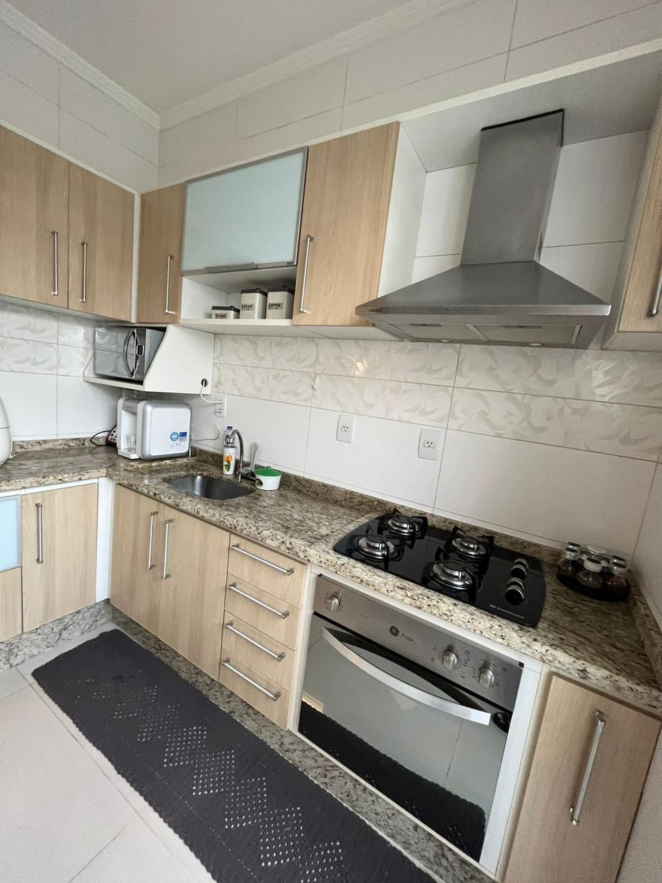 Cozinha planejada com cooktop, forno e coifa