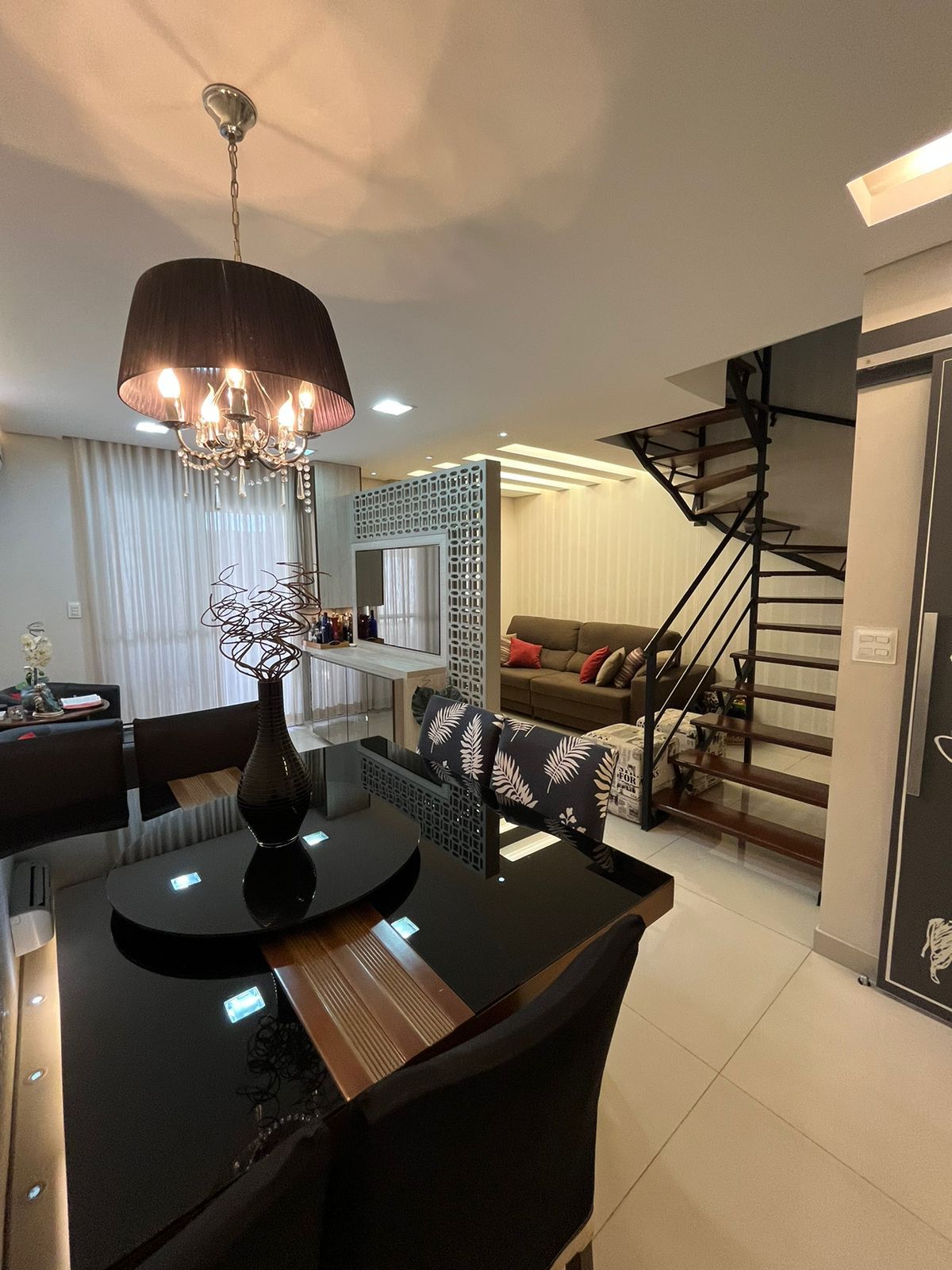 Sala de jantar com lustre e mesa de vidro