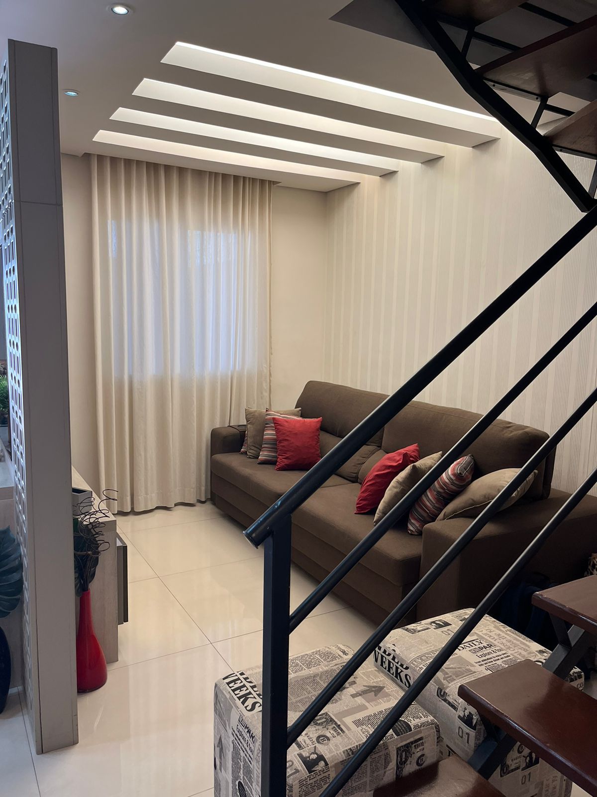 Sala com sofá e escada metálica