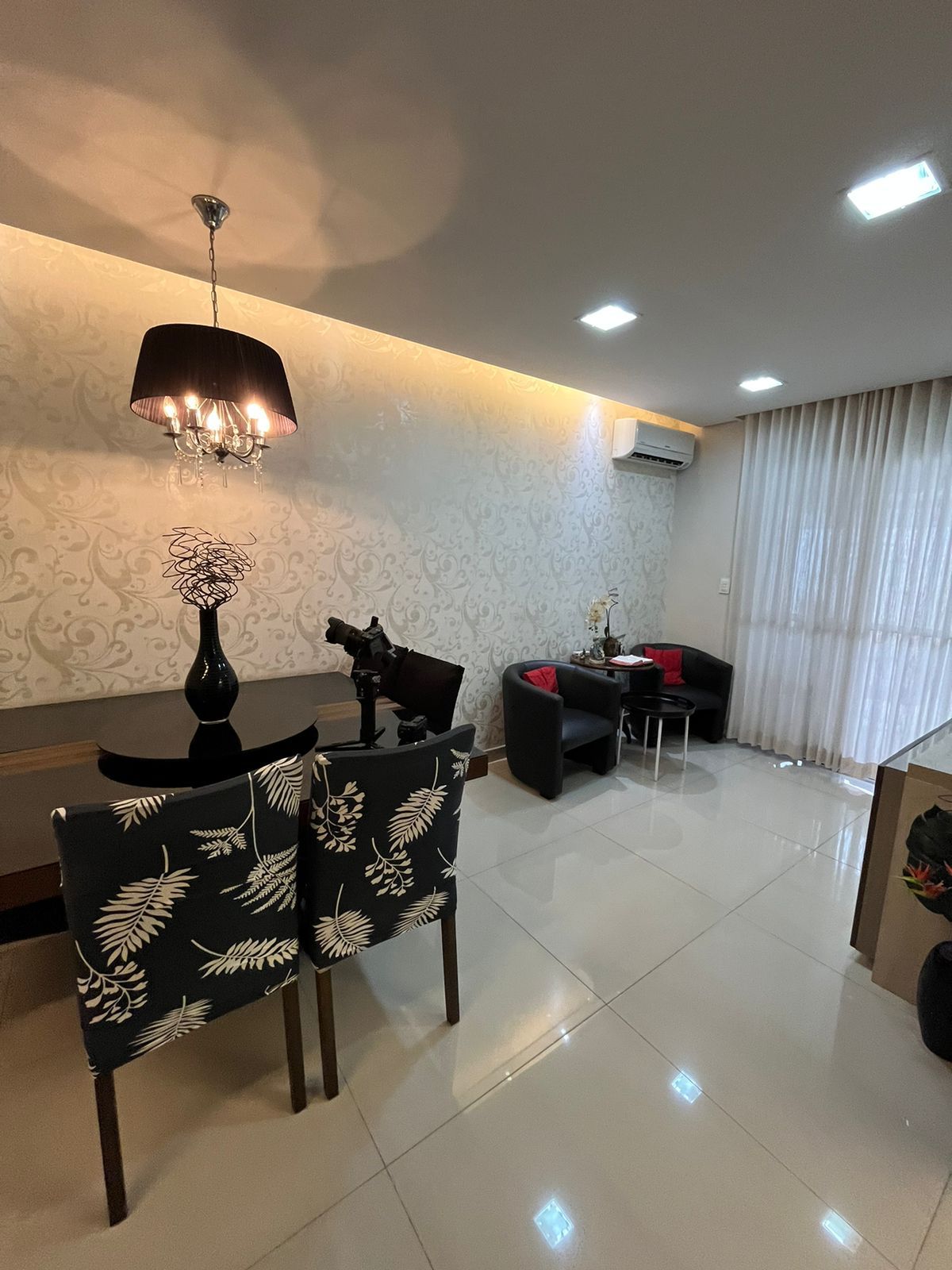 Sala de estar com poltronas e papel de parede arabesco